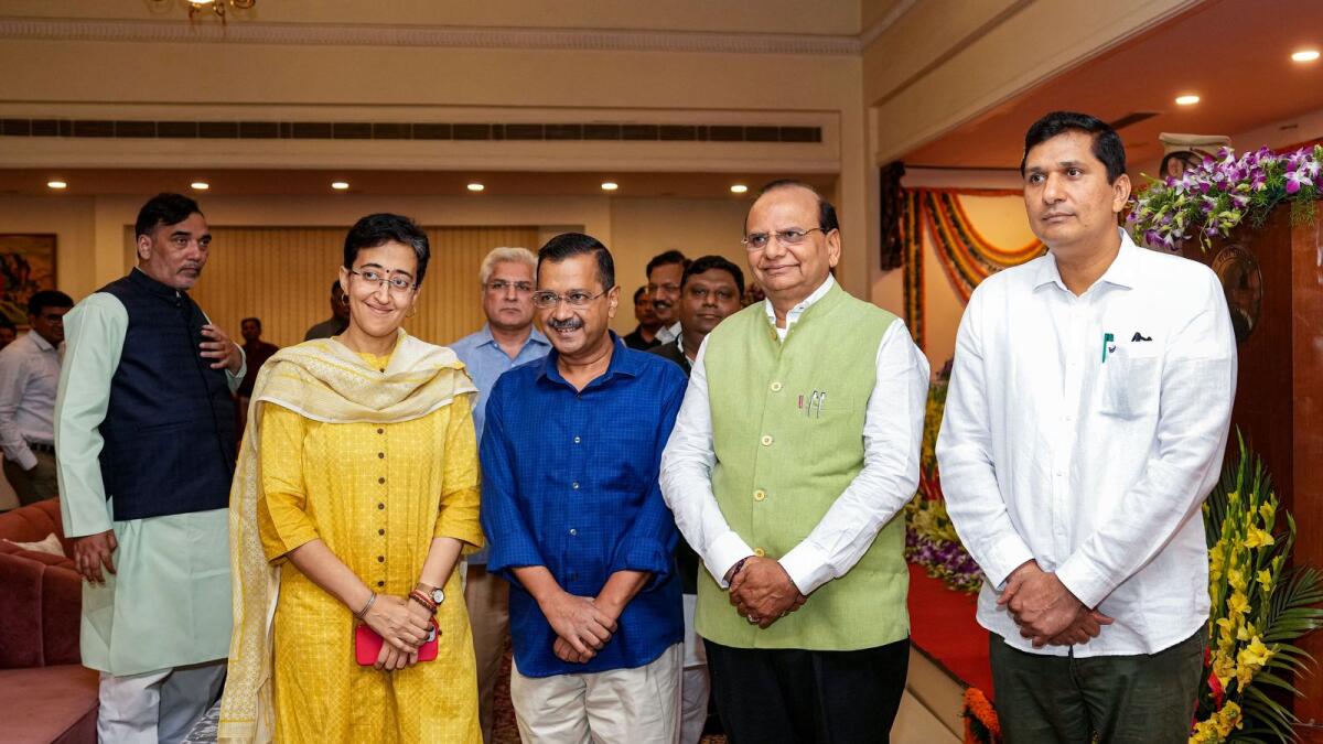 Delhi Lt. Governor Vinai Kumar Saxena (second from right) and Chief Minister Arvind Kejriwal (second from left) with newly sworn-in Delhi Cabinet Ministers Atishi Marlena (left) and Saurabh Bharadwaj, at Raj Niwas in New Delhi on Thursday. — PTI