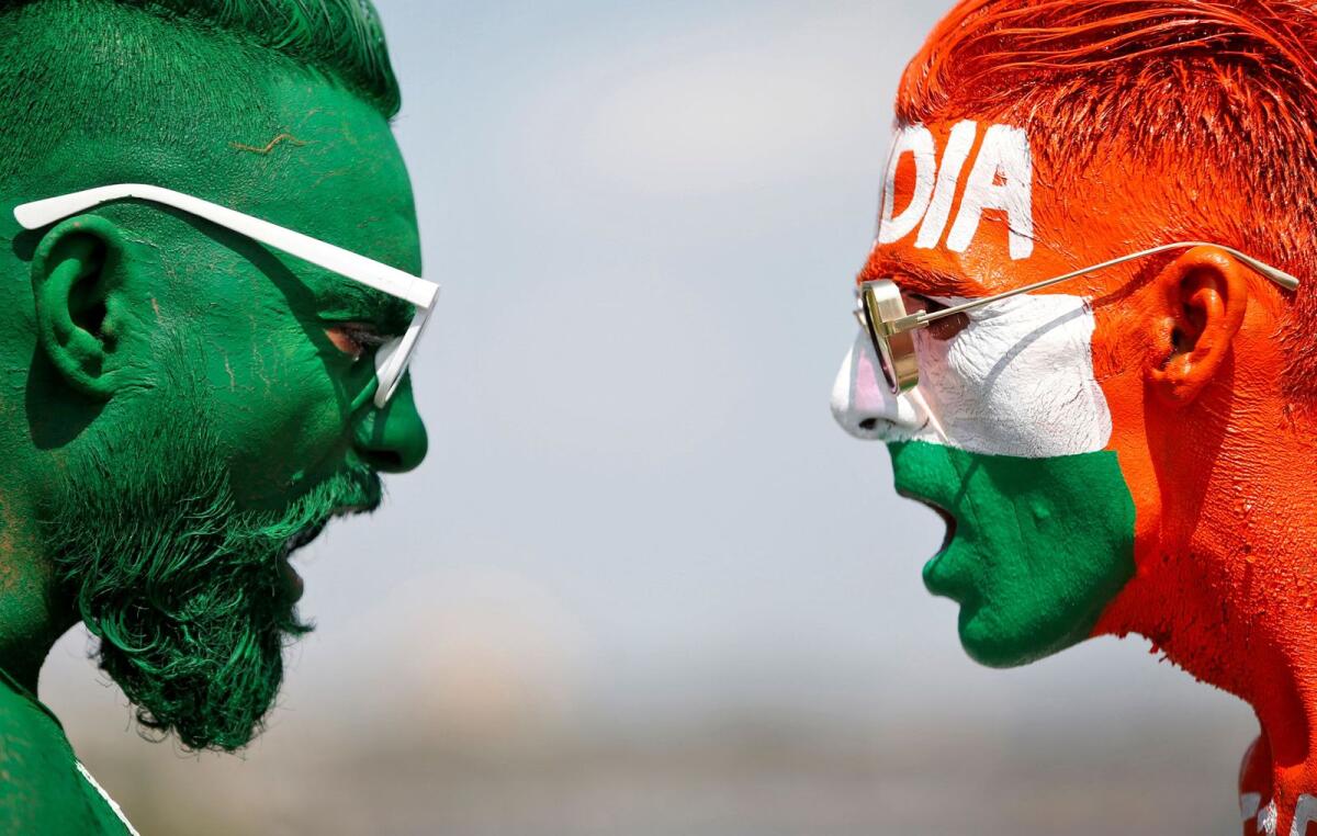 File photo of cricket fans,with their faces painted in the Indian and Pakistani national flag colours. - Reuters