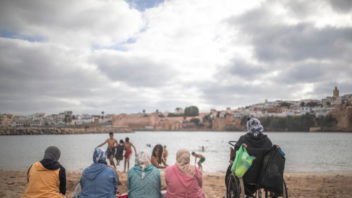 Women watch as their kids swim at a reopened beach after lockdown measures were lifted in Sale, Morocco. Photo: AP