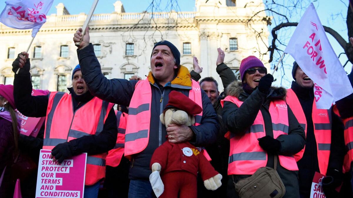 A Royal Mail worker holds a toy depicting Postman Pat as members strike over pay and conditions, outside of the Houses of Parliament in London, Britain, on December 9, 2022. — Reuters file