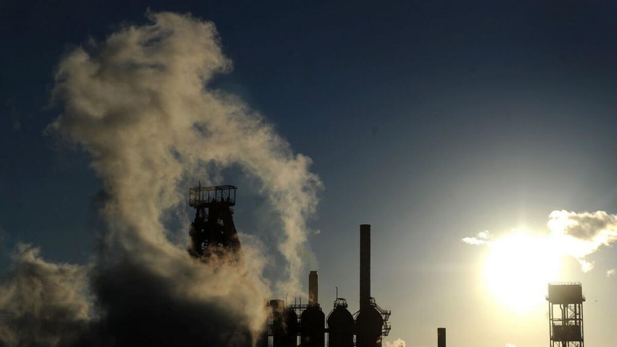 The sun sets as smoke and steam rises from the Tata steel plant in Port Talbot, Wales.