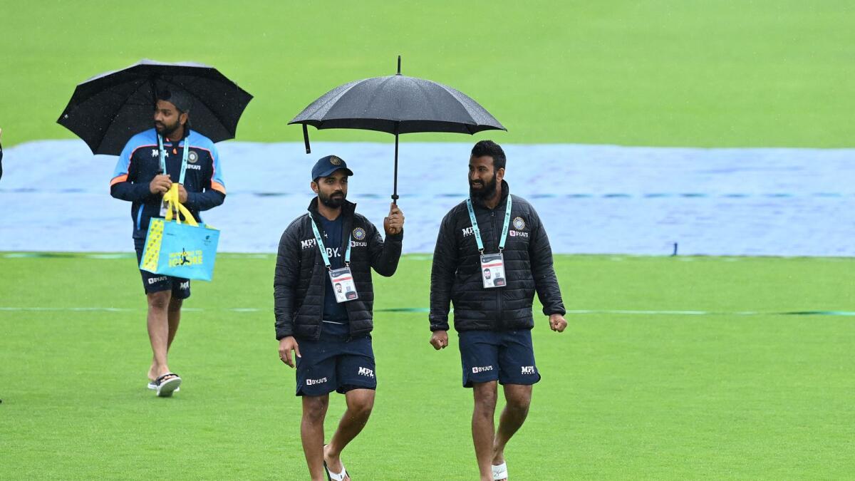 India's Rohit Sharma, Ajinkya Rahane and Cheteshwar Pujara walk on the pitch as rain stops play on the fourth day of the ICC World Test Championship Final. — AFP