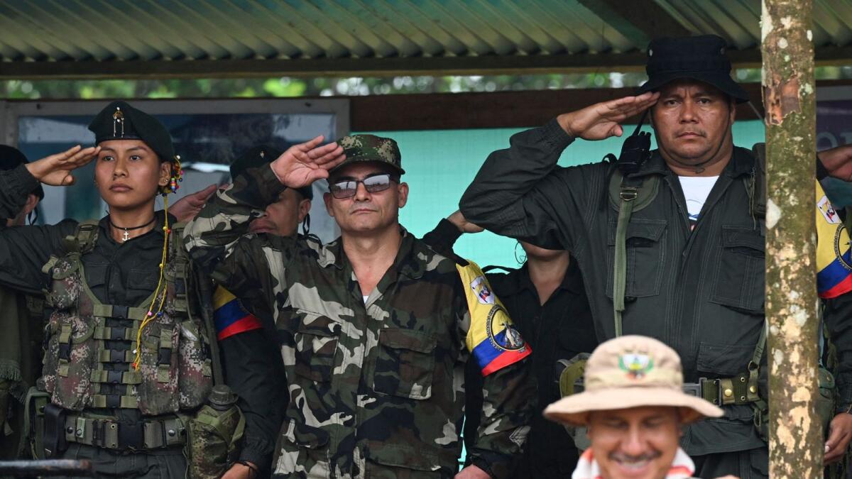 FARC EP dissidence top commander, aka Ivan Mordisco (C), gives a military salute next to commander Calarca (R) during a meeting with local communities in San Vicente del Caguan, Caqueta department, Colombia, on Sunday.— AFP