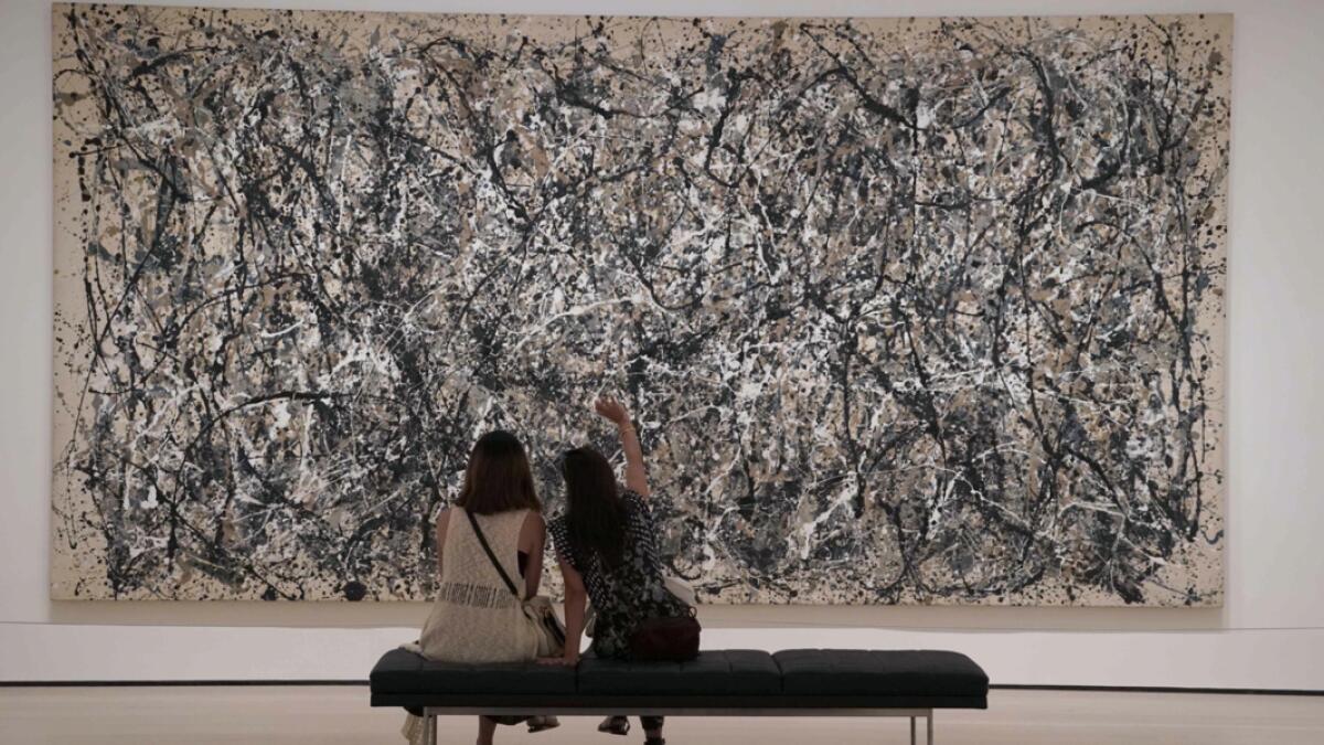 Women look at a Jackson Pollock painting as the Museum of Modern Art (MoMA) reopens its doors to the public in New York, after being closed since March 12, 2020 due to Covid-19. Photo: AFP