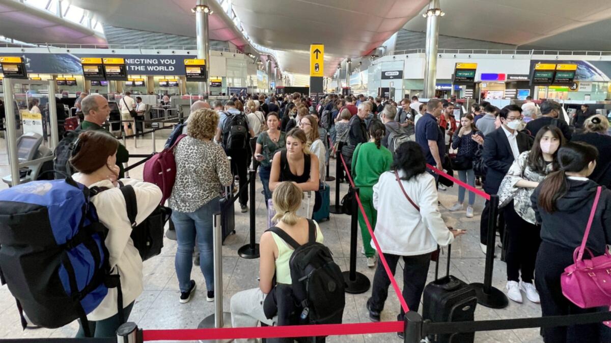 Travellers queue at security at Heathrow Airport in London. — AP file