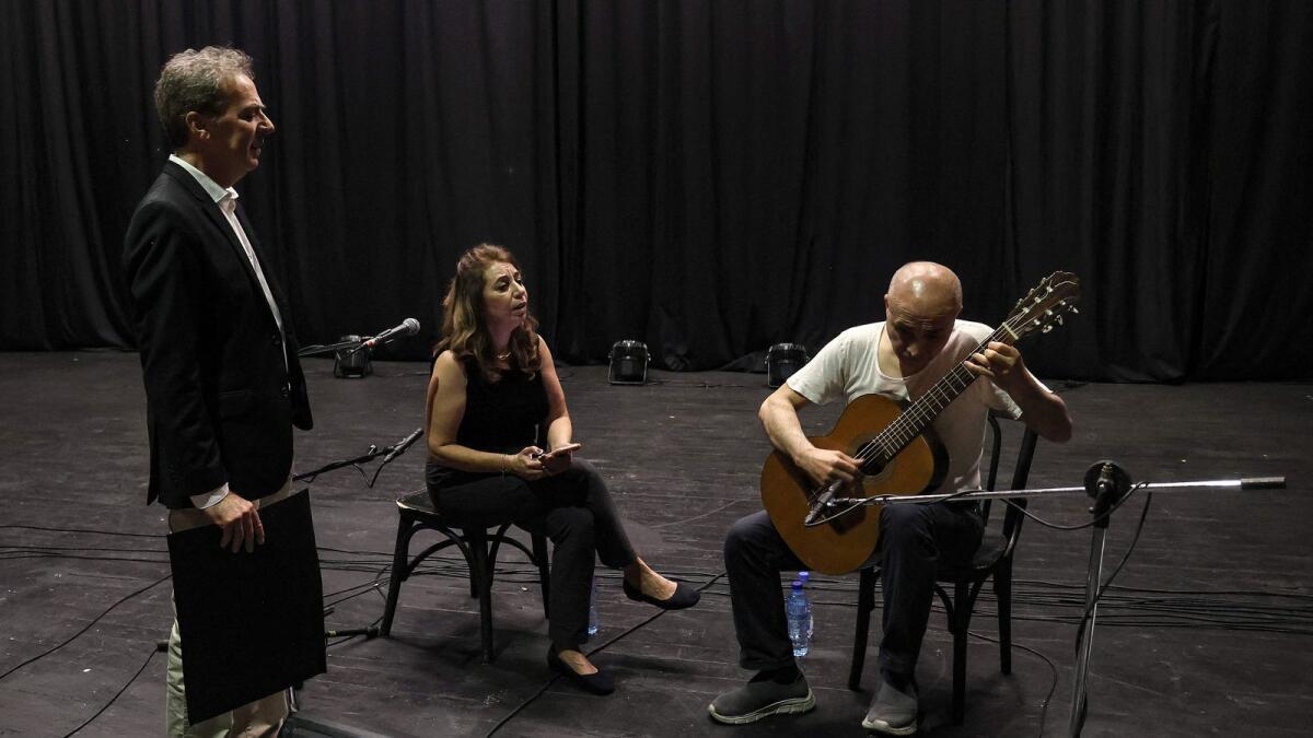 Lebanon's national conservatory of music teacher, soprano and concert organiser Ghada Ghanem (C) guest singer Elie Rizkallah (R) and conservatory music teacher Fadi Rashid, take part in a rehearsal session at the Al-Madina theatre in Beirut, on April 17, 2023.  — AFP