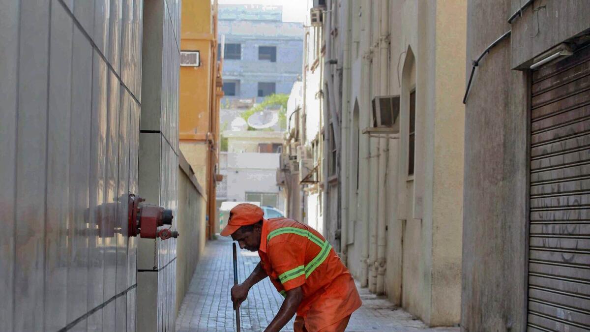 A cleaner cleaning an alley in Satwa in Dubai.-Photo by Leslie Pableo/Khaleej Times