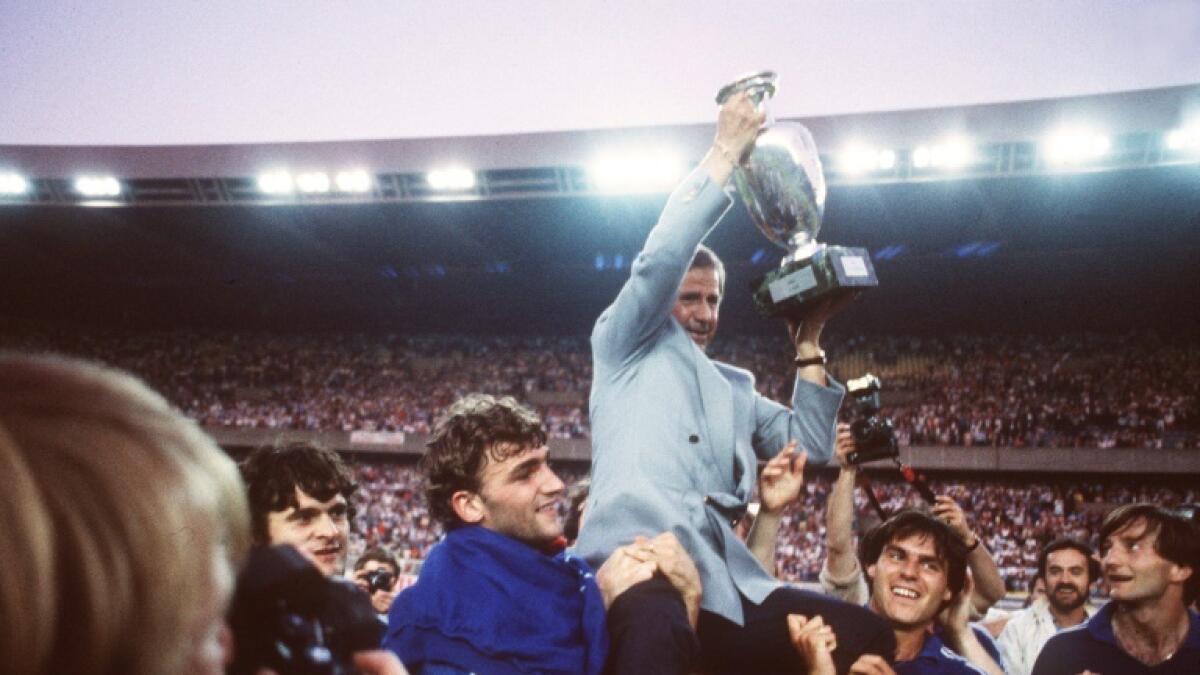 Michel Hidalgo, carried by several France players, holds aloft the European Championship trophy after their 2-0 win over Spain in the final in 1984. - AFP file