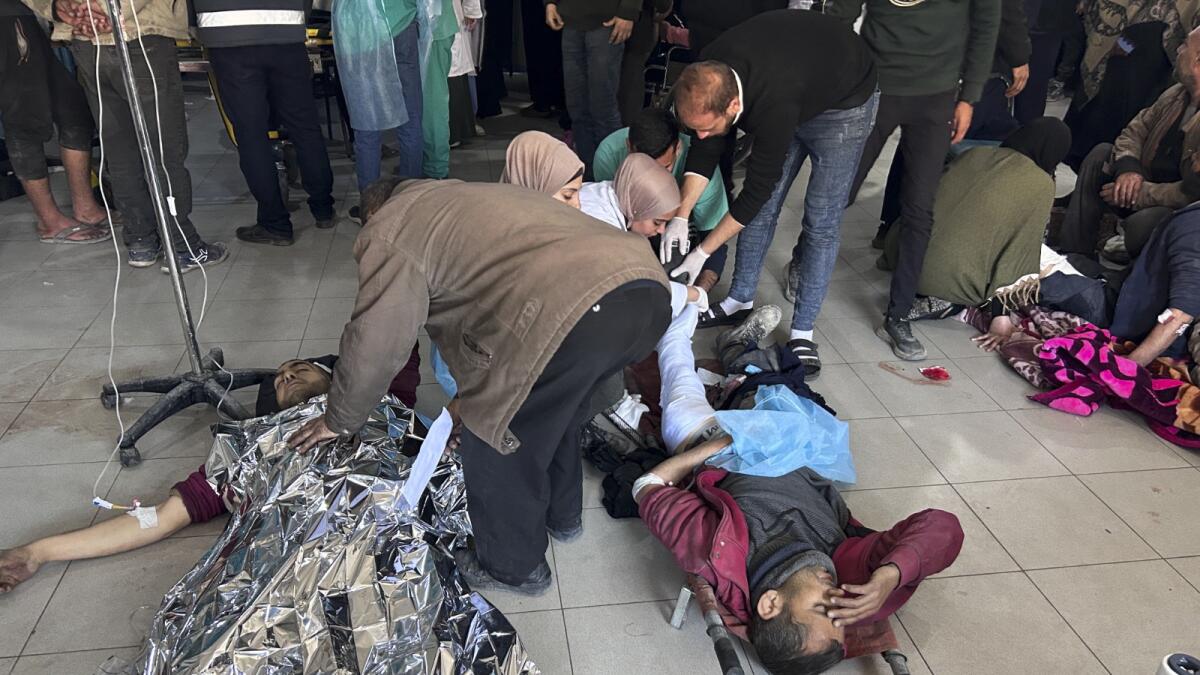 Palestinians wounded in an Israeli strike while waiting for humanitarian aid on the beach in Gaza City are treated in Shifa Hospital. — AP