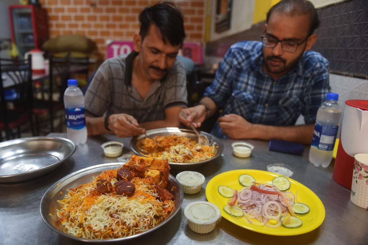 People eat biryani at a restaurant in Karachi. — AFP