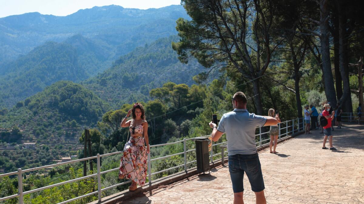 Tourists take photos in town of So´ller in the Balearic Island of Mallorca, Spain. Britain has put Spain back on its unsafe list and announced on Saturday that travelers arriving in the UK from Spain must now quarantine for 14 days. Photo: AP