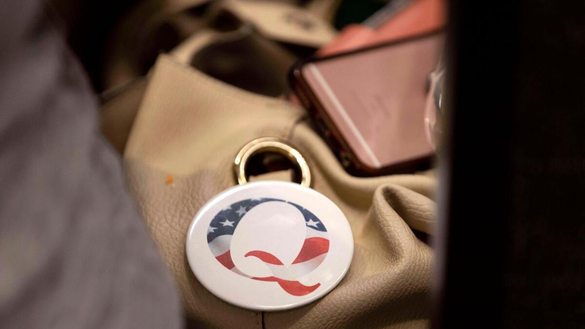 A QAnon conspiracy theory button sits affixed to the purse of an attendee of the Nebraska Election Integrity Forum