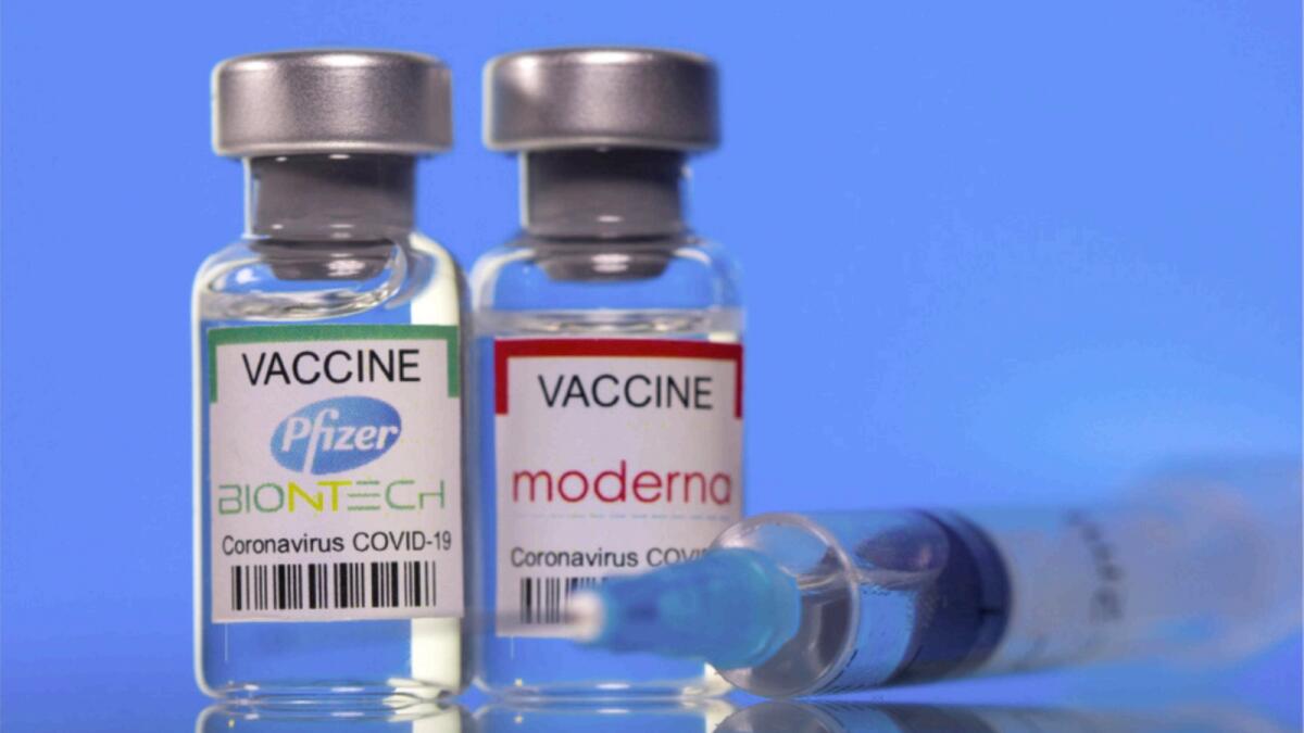 Vials with Pfizer-BioNTech and Moderna vaccine labels. — Reuters