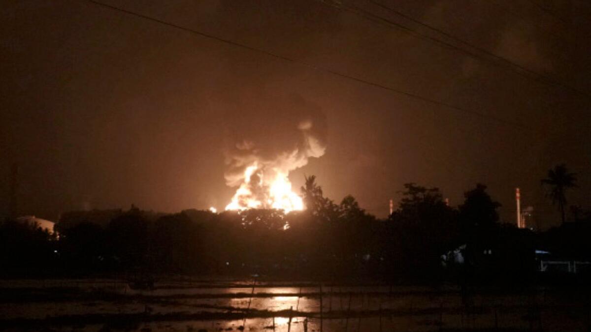 The sky glows from the fire that razes through an oil refinery owned by the national oil company Pertamina, in Cilacap, Central Java, Indonesia, on Saturday. AP