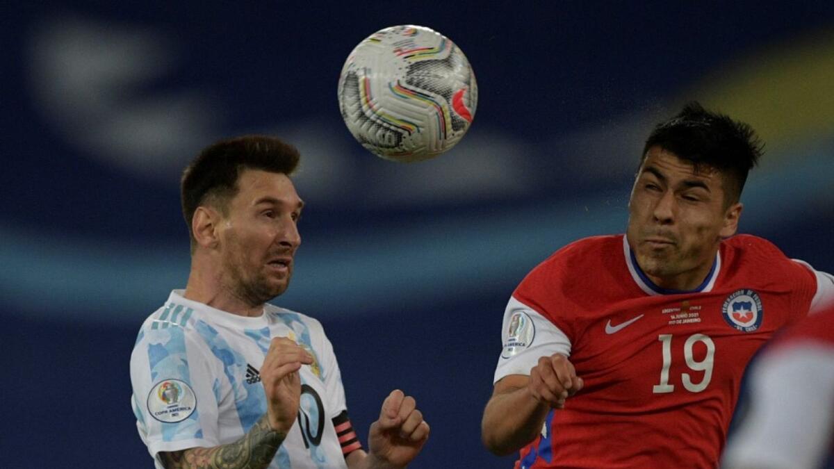 Lionel Messi (left) heads the ball during the match against Chile. (AFP)
