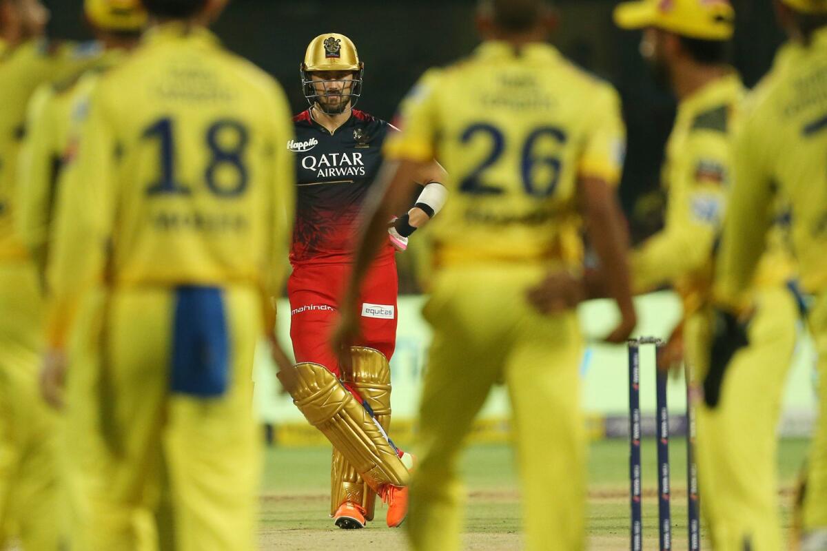 Faf Du Plessis of Royal Challengers Bangalore looks on as Chennai Super Kings players celebrate a wicket. — IPL