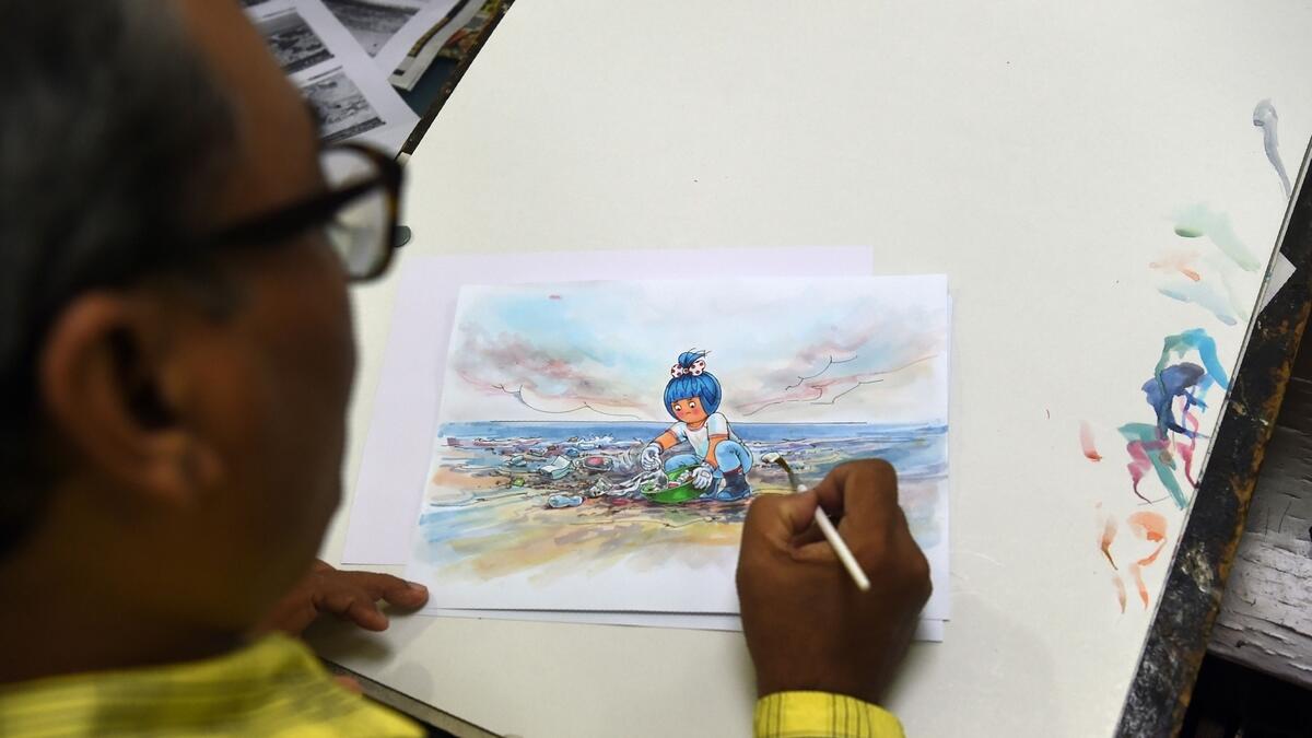 Indian cartoonist Jayant Rane gives finishing touches to a sketch of a new Amul advert for World Environment Day in Mumbai.