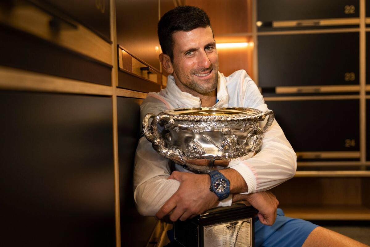 Novak Djokovic of Serbia hugs the Norman Brookes Challenge Cup in the locker-room after defeating Stefanos Tsitsipas of Greece in the final at the Australian Open. — AP