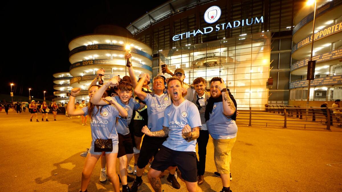 Manchester City fans celebrate outside Etihad Stadium in Manchester.