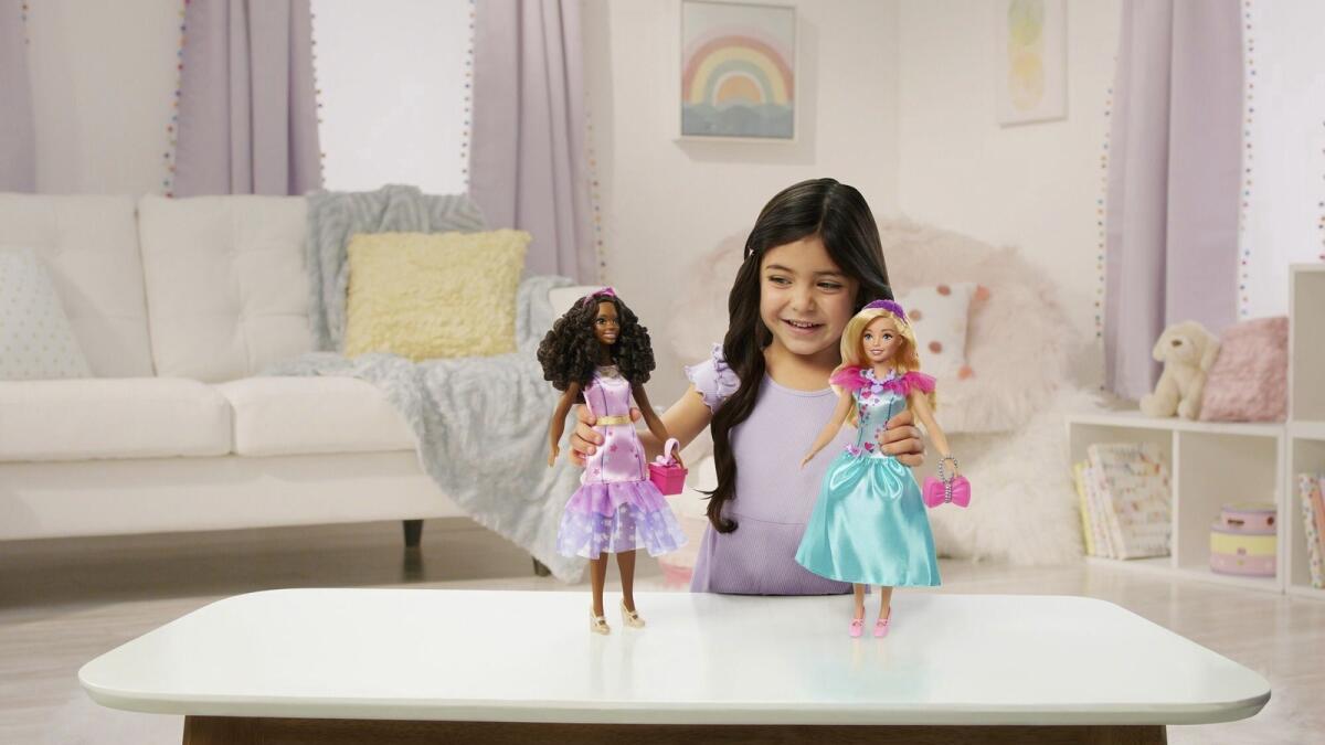 This image released by Mattel shows a child playing with Teresa, a My First Barbie deluxe set, new dolls made specifically for children as young as 3. — AP