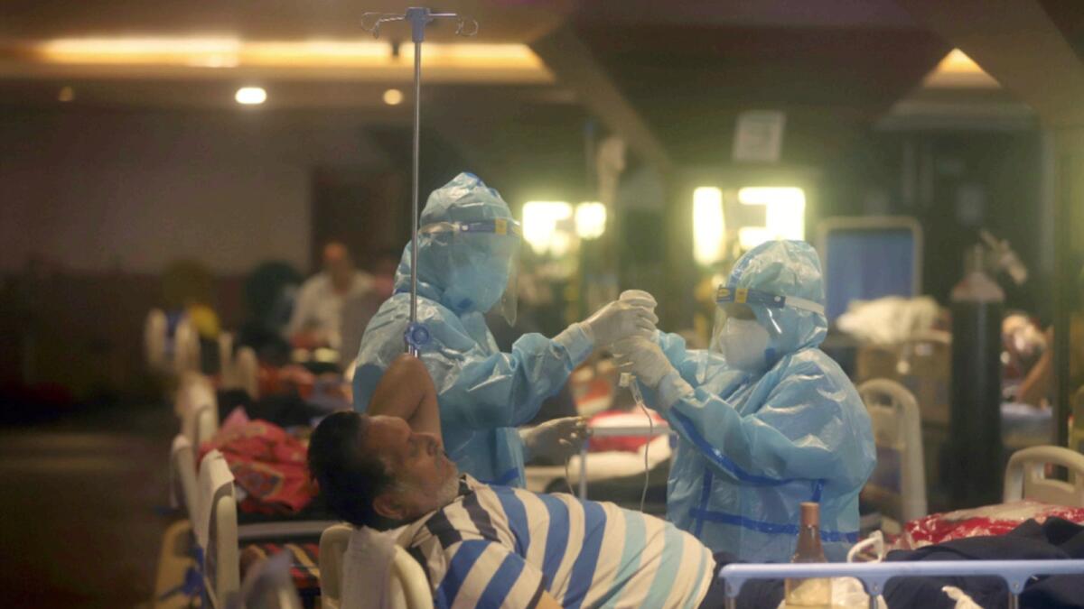 Health workers attend to Covid-19 patients at a makeshift hospital in New Delhi. — AP