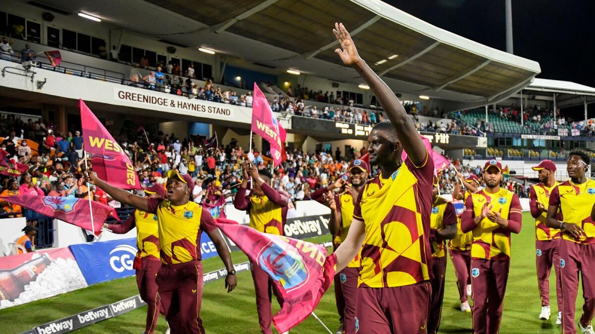 Jason Holder (centre) and his teammates celebrate after West Indies beat England in the the 5th and final T20I against England. (AFP)