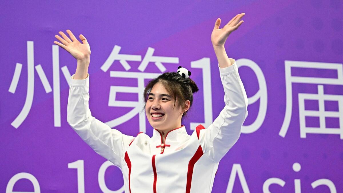 Gold medallist China's Zhang Yufei celebrates on the podium during the medals ceremony for the women's 50m butterfly stroke at the Hangzhou 2022 Asian Game. - AFP