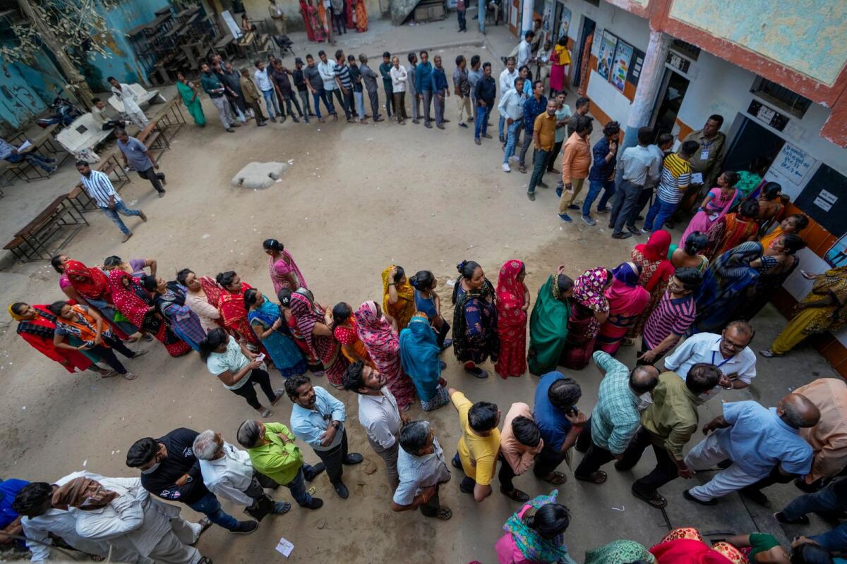 People stand in queue to cast their votes during the second phase of Gujarat state legislature elections in Ahmedabad, India, on December 5, 2022. — AP file