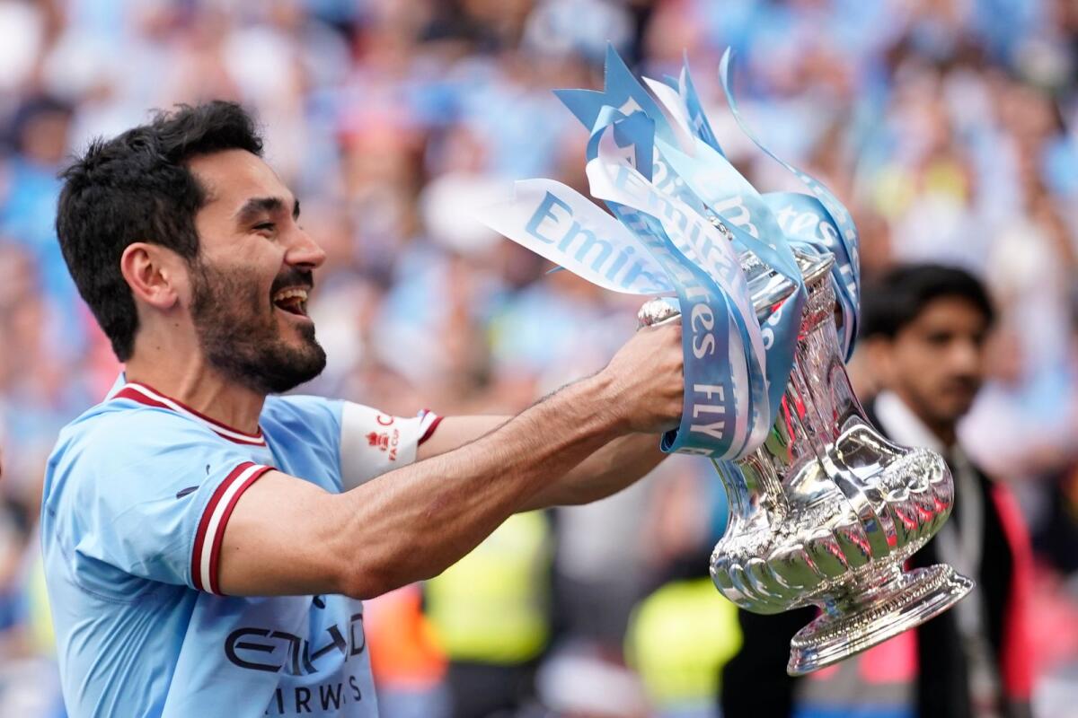 Manchester City's Ilkay Gundogan holds up the winners trophy as he celebrates winning the FA Cup. — AP