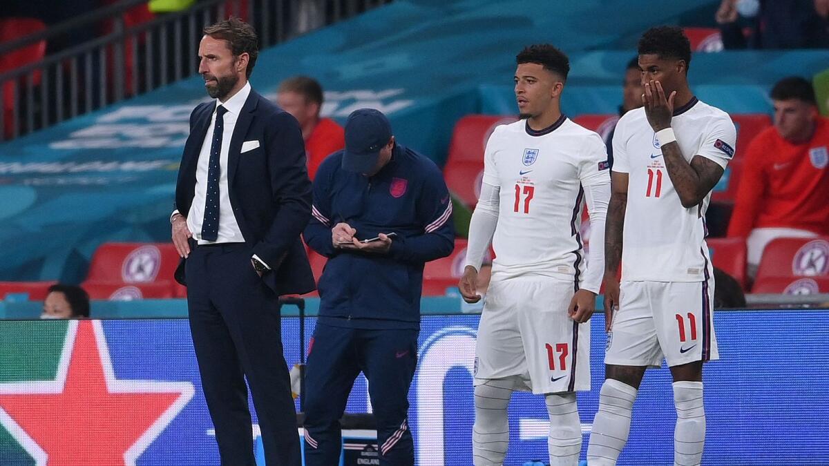England's coach Gareth Southgate (left) stands next to England's forward Jadon Sancho (centre) and England's forward Marcus Rashford during the final. — AFP