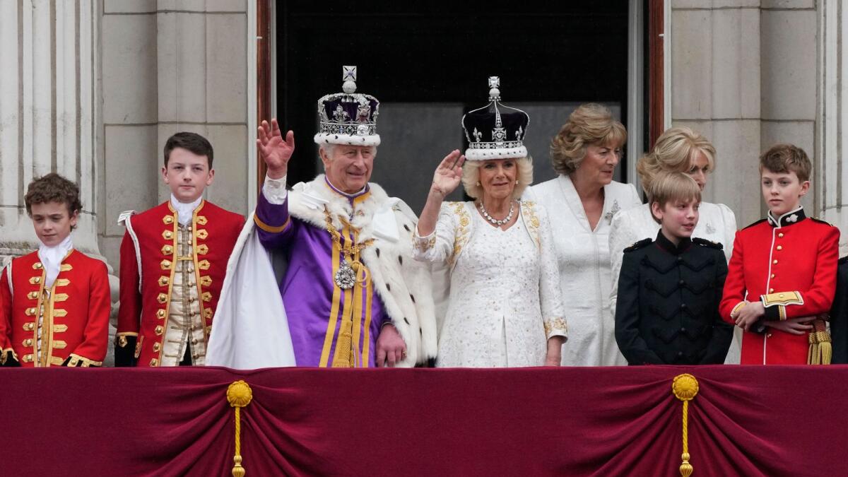 Britain's King Charles III and Queen Camilla wave to the crowds from the balcony of Buckingham Palace after the coronation ceremony in London, on Saturday. — AP
