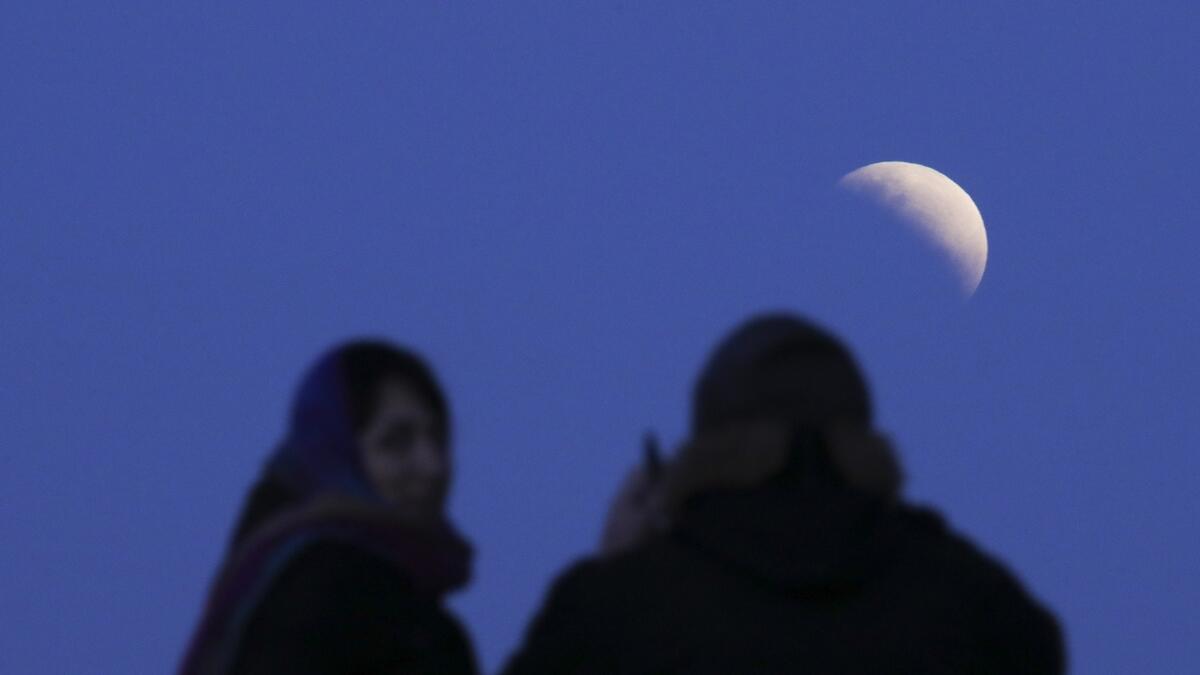 A couple watches a partial lunar eclipse, in Buenos Aires, Argentina. AP 