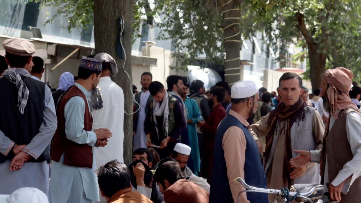 Afghans wait for hours to try to withdraw money, in front of Kabul Bank. — AP