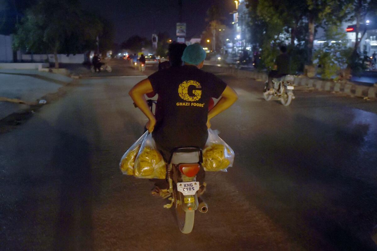 Staff of an eatery ride a bike as they carry packets of biryani for the poor people in Karachi. At Ghazi Foods, 28-year-old Ali Nawaz paddles out dozens of portions of biryani into plastic pouches, which are delivered to poor neighbourhoods on motorbikes. — AFP