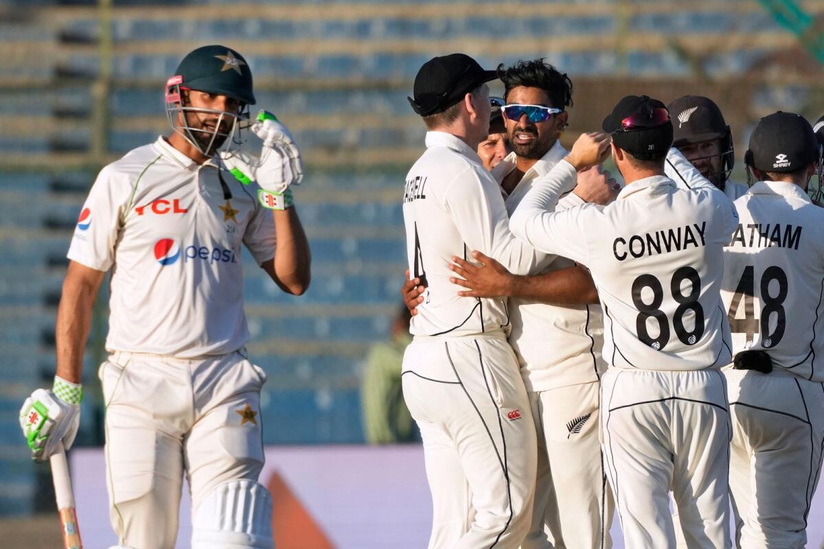 New Zealand's Ish Sodhi (centre) celebrates with teammates after taking the wicket of Pakistan's Shan Masood. — AP