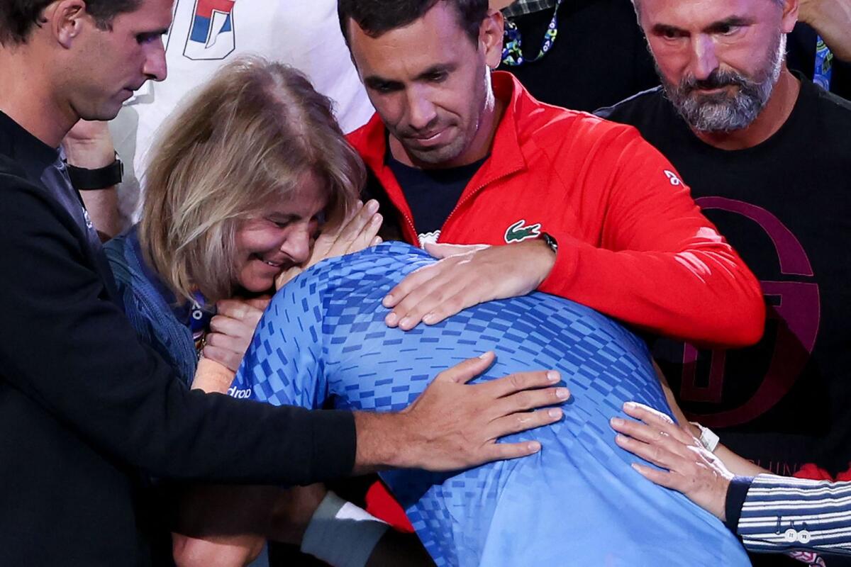 Novak Djokovic (centre) celebrates with his mother Dijana Djokovic (left) after victory against Stefanos Tsitsipas. — AFP