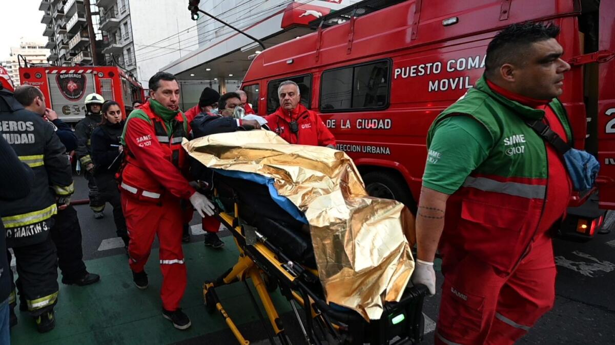 Paramedics carry an injured person on a stretcher during a fire in an apartment building  in Buenos Aires. – AFP