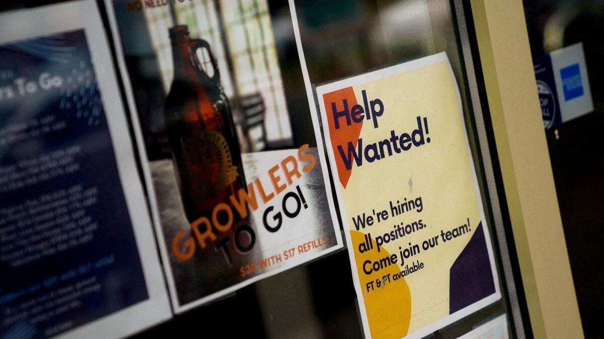 An employee hiring sign is seen in a window of a business in Arlington, Virginia. — Reuters