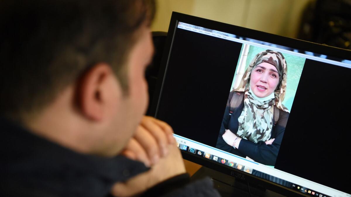 A man watches a video of Afghan woman Muzgha on a computer screen in Kabul.