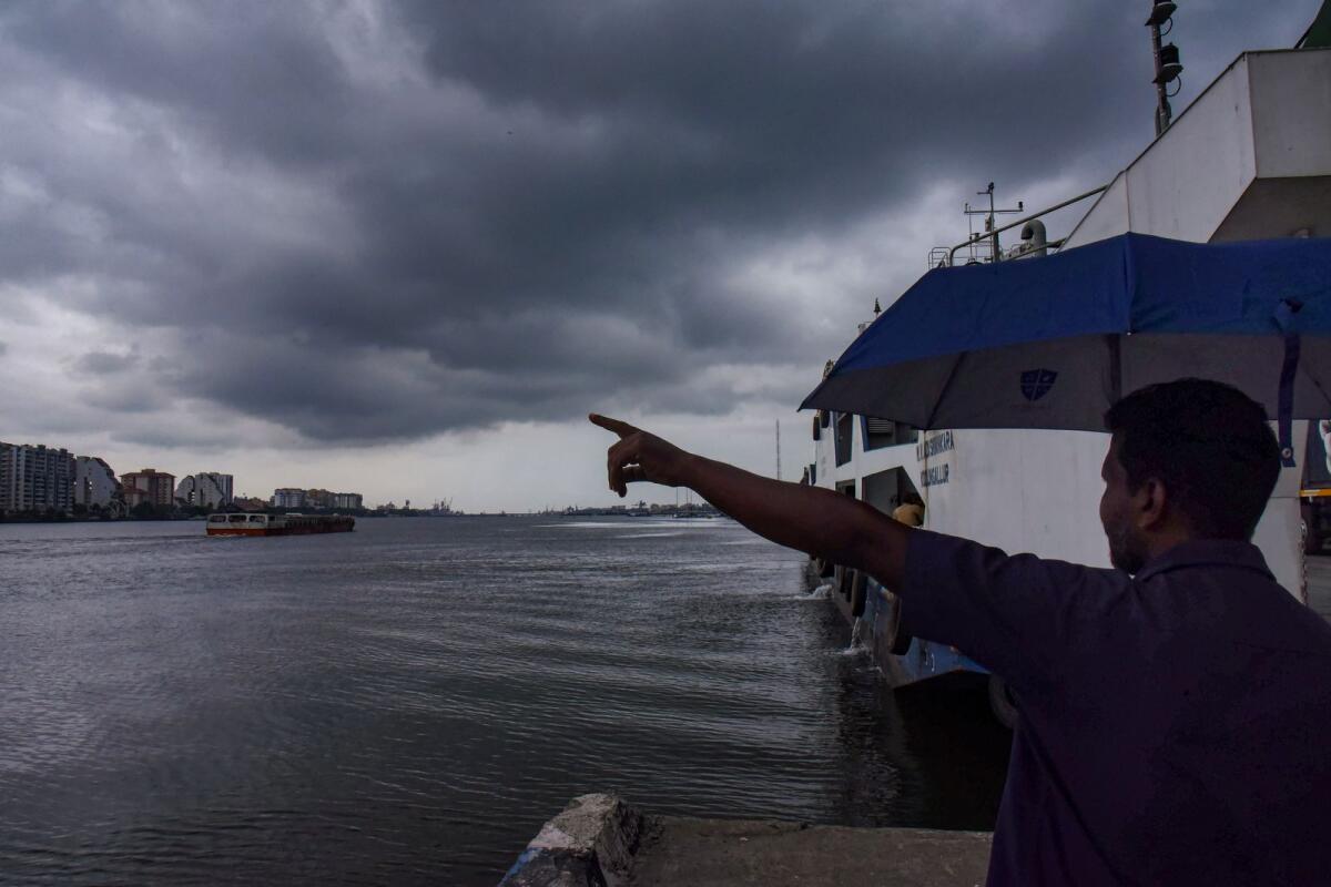 A man points at dark clouds covering Kochi’s skyline on Friday. A slight delay is expected in the onset of the southwest monsoon over Kerala and it is likely to arrive by June 4, according to the India Meteorological Department. Photo: PTI