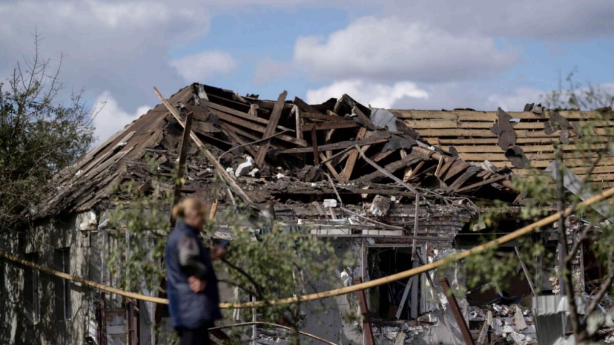 A woman stands in front of a house that was heavily damaged after a Russian attack in Sloviansk. — AP