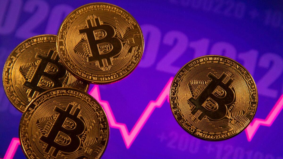 A representation of virtual currency Bitcoin is seen in front of a stock graph in this illustration. The largest cryptocurrency was trading down 8.8 per cent at $33,058, its lowest since July 23, taking losses from its all-time high of $69,000 hit in November past 50 per cent. — File photo