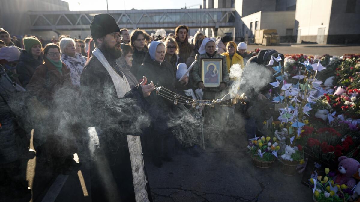 An Orthodox priest conducts a service at a makeshift memorial in front of the Crocus City Hall in the outskirts of Moscow. — AP