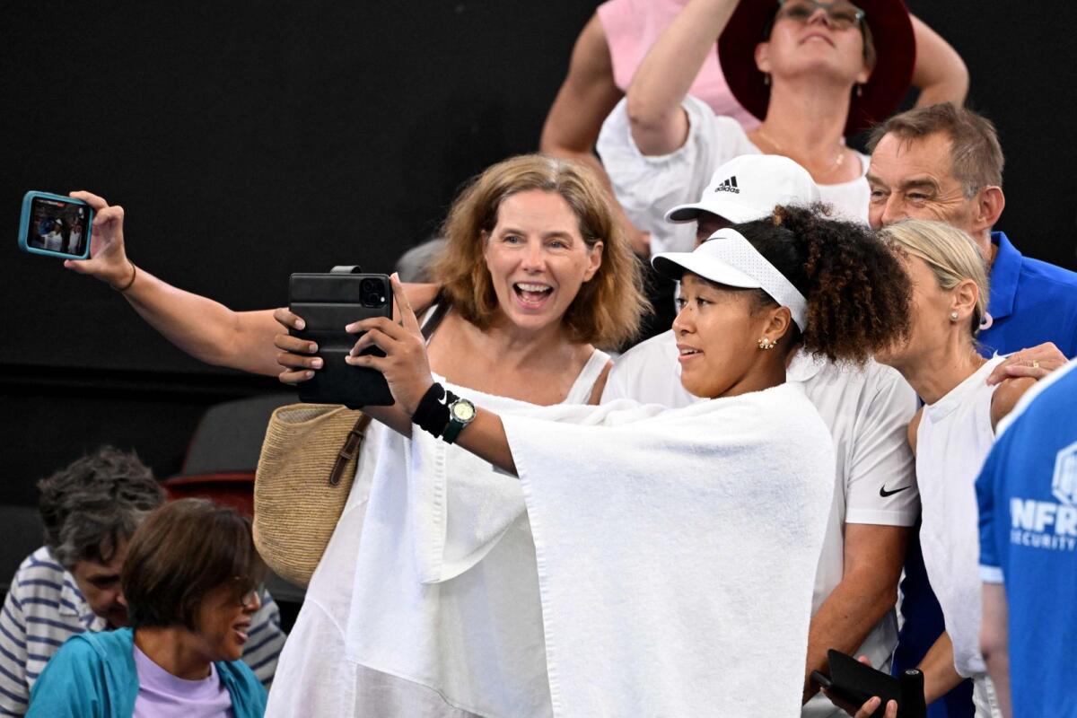 Japan's Naomi Osaka (right) takes a selfie with fans after her victory over Germany's Tamara Korpatsch. — AFP