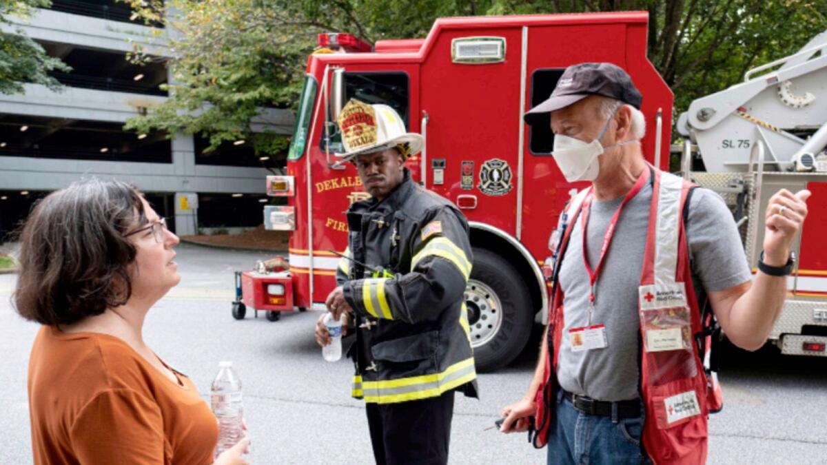 Dunwoody Mayor Lynn Deutsch, left, talks with a Red Cross worker as emergency workers respond following an apartment explosion. — AP