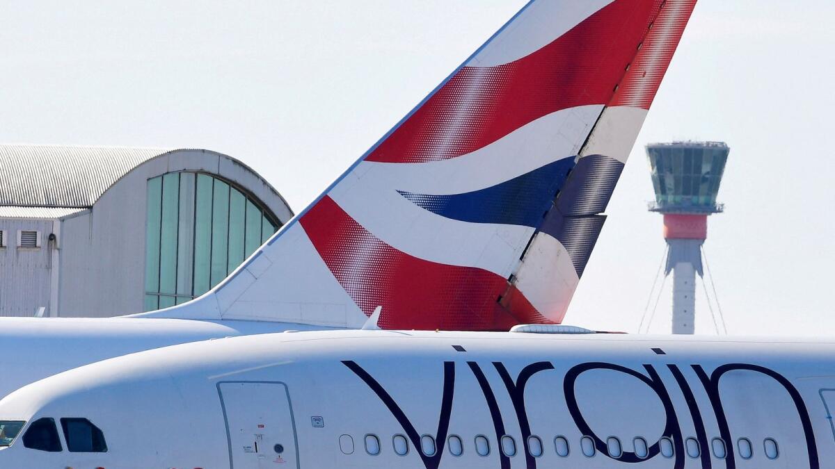 A British airways aeroplane tailfin and a Virgin Atlantic areoplane are seen with the control tower at Heathrow airport, London. — Reutrers file photo used for illustrative purpose only