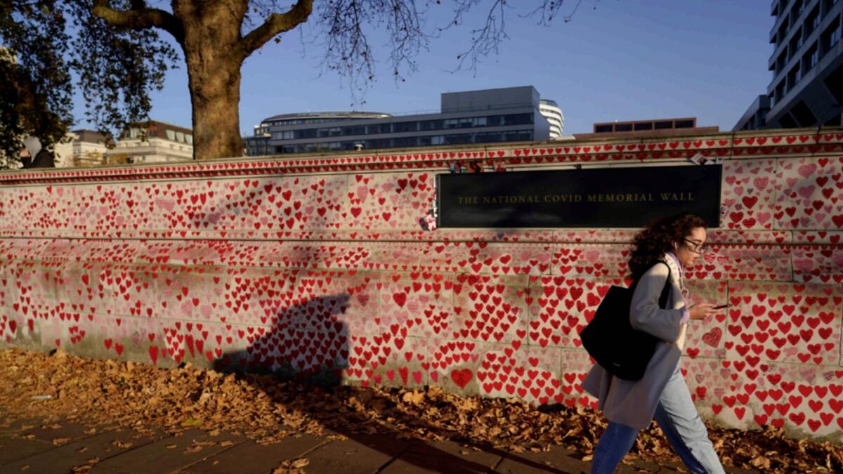 A person walks past the National Covid Memorial Wall on the south bank of the river Thames, in London. — AP