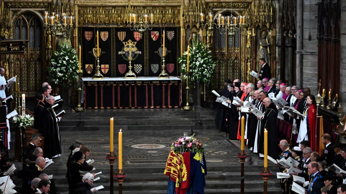 Members of the Royal family and guests sing as the Queen's coffin, draped in the Royal Standard, lies by the altar during the State Funeral Service.