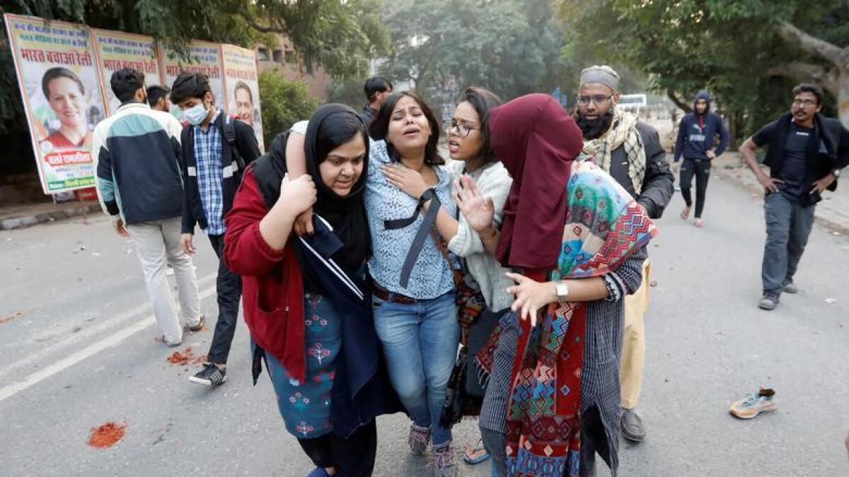 A woman is helped after she was injured during a protest against a new citizenship law, in New Delhi. Reuters