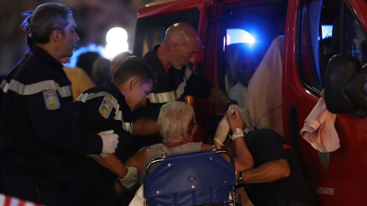 Rescue workers help an injured woman to get in an ambulance in the French Riviera town of Nice.